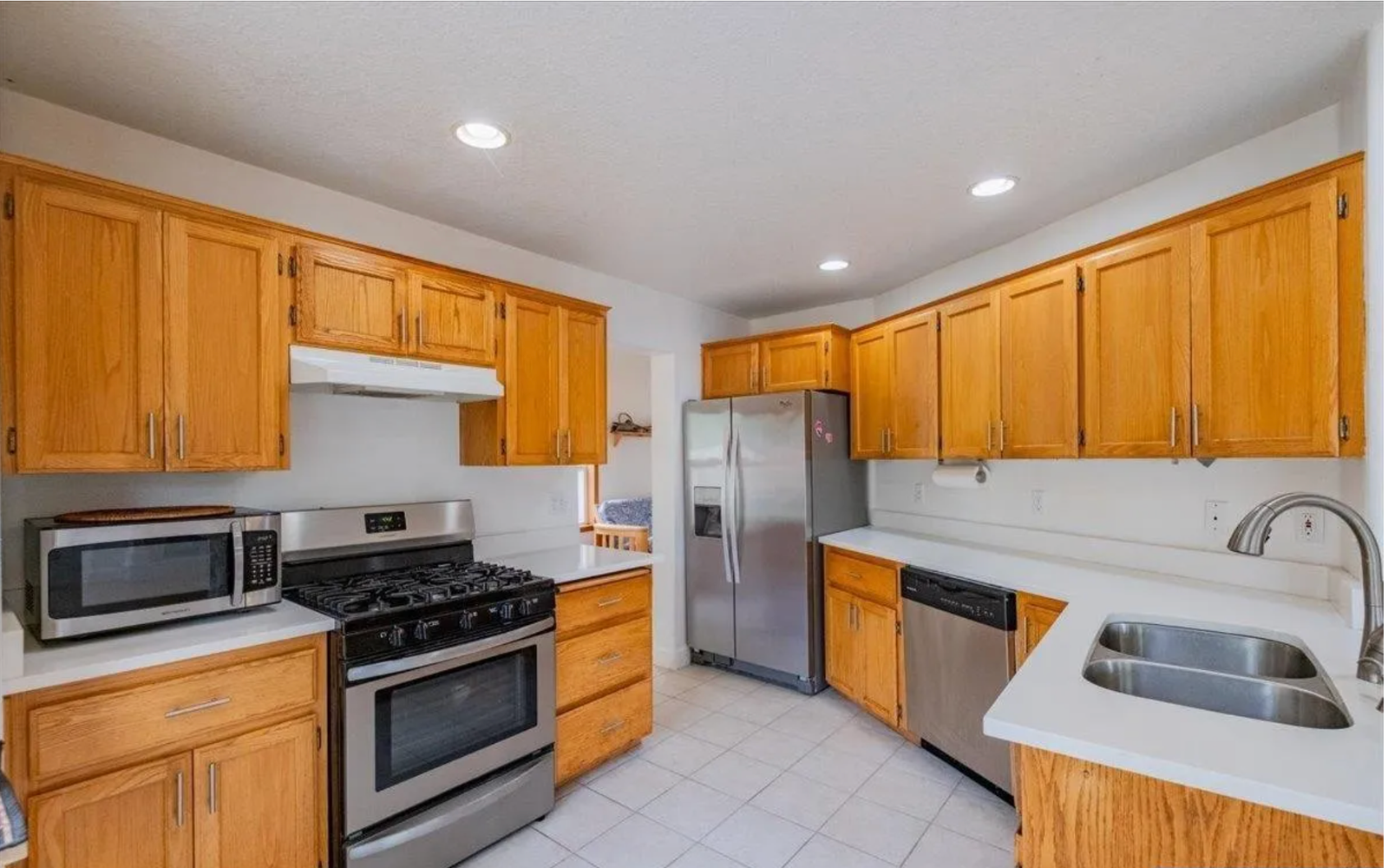 Kitchen before redesign, with dated oak cabinetry