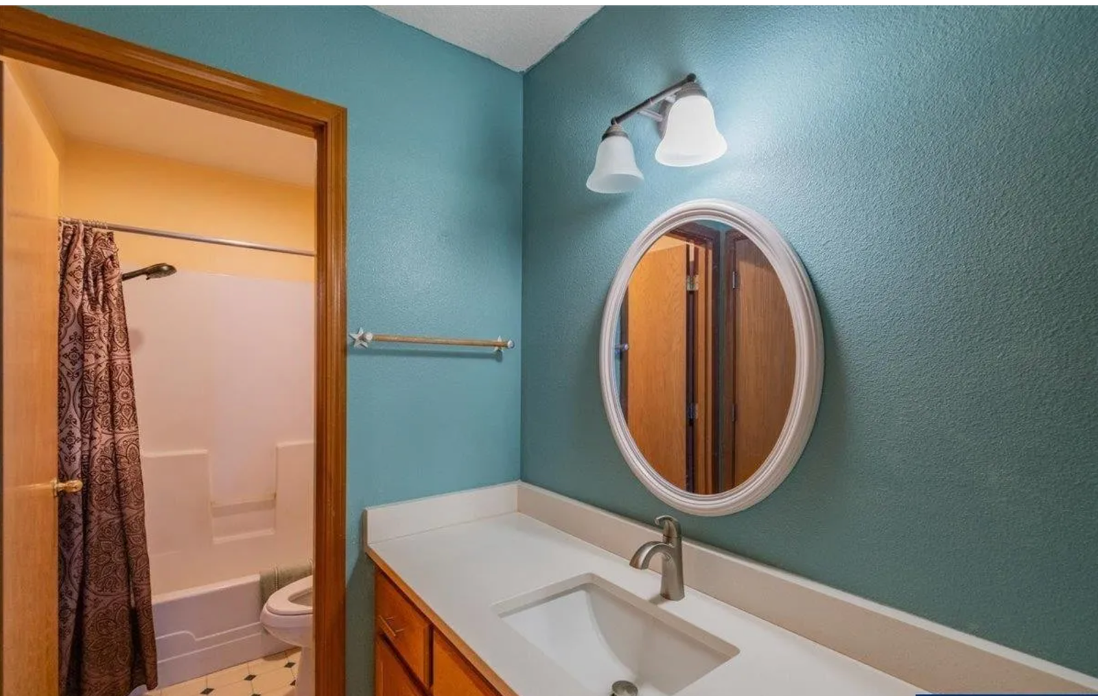 Primary bathroom before redesign, with dated teal walls